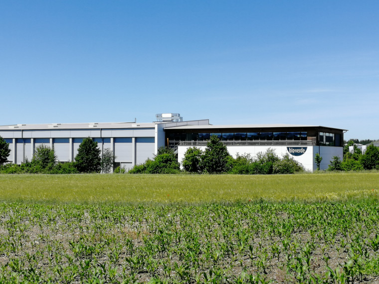 Auf dem Bild sieht man das Bioverde Fabrikgebäude an einer grünen Wiese.