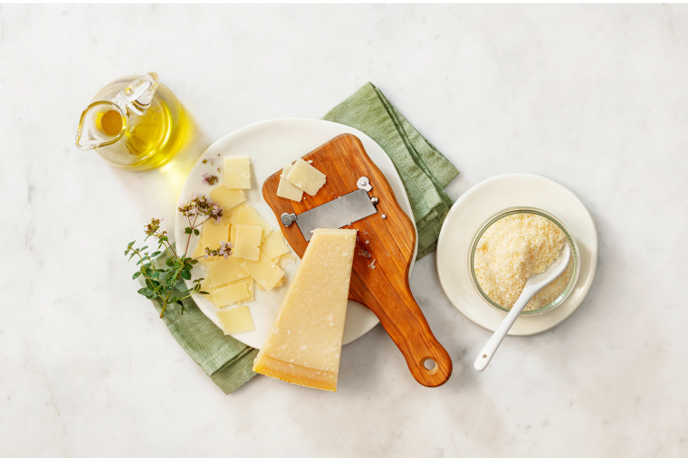 Auf dem Bild ist ein Brett mit frisch gehobeltem Parmesan